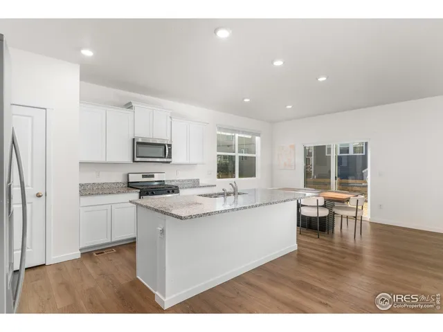 a kitchen with a sink and wooden floor