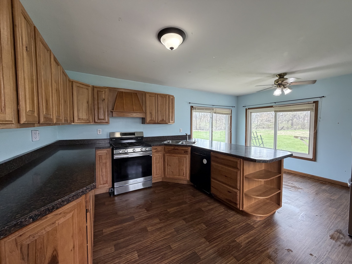 616 East Main Street Amboy, IL 61310 - Photo 20 of 24 a kitchen with granite countertop wooden floors a stove and a microwave