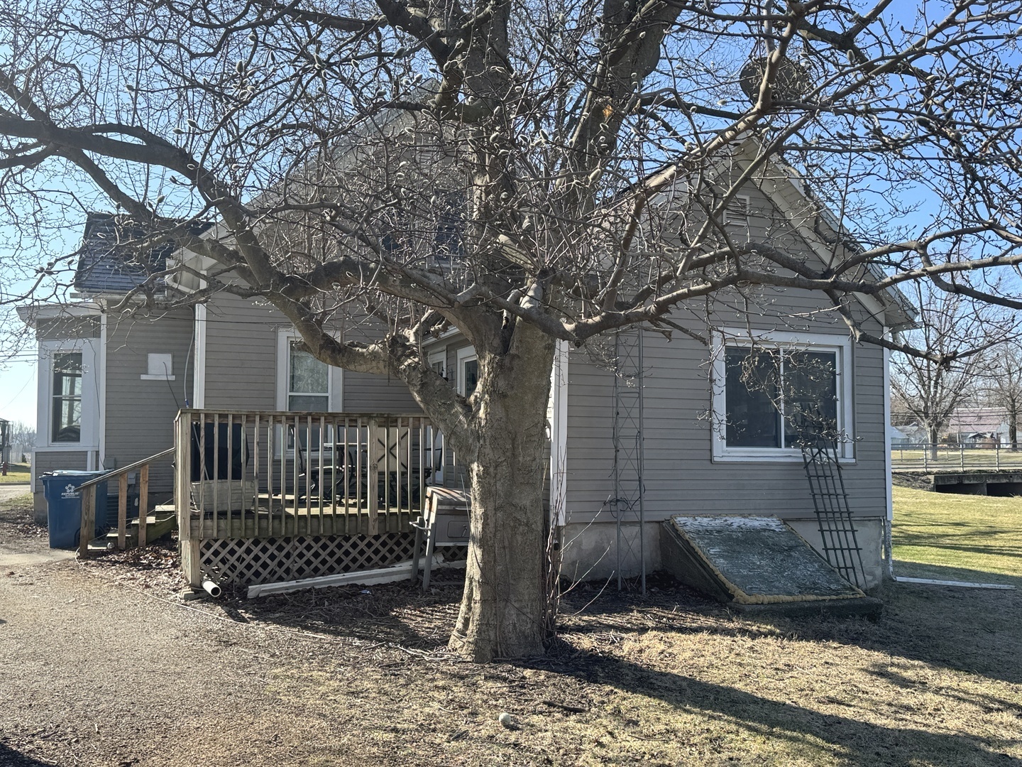 616 East Main Street Amboy, IL 61310 - Photo 3 of 24 a view of a house with a wooden fence and a large tree