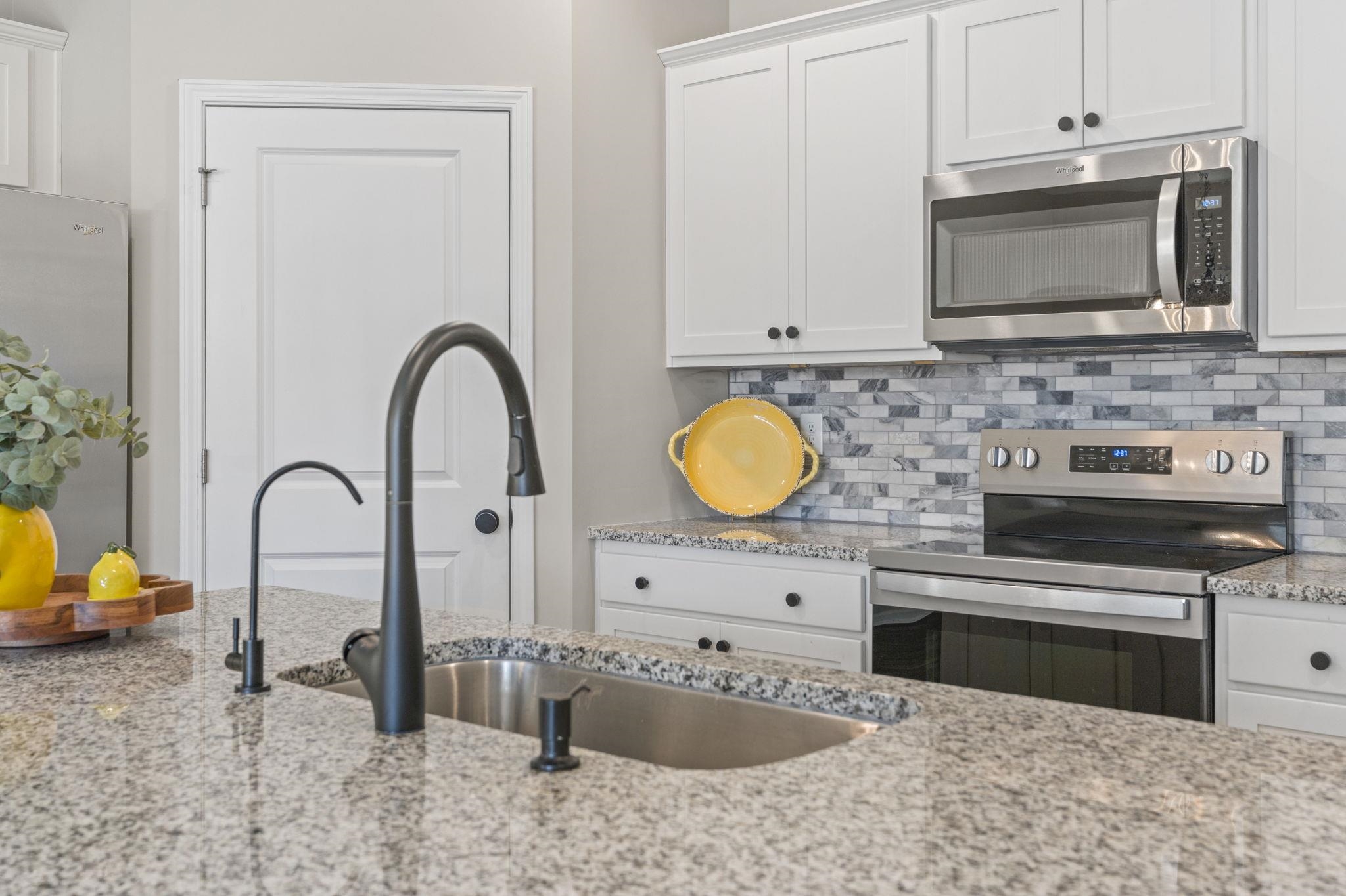143 Ardeer Court Little River, SC 29566 - Photo 12 of 40 Kitchen with appliances with stainless steel finishes, white cabinetry, decorative backsplash, and light stone counters