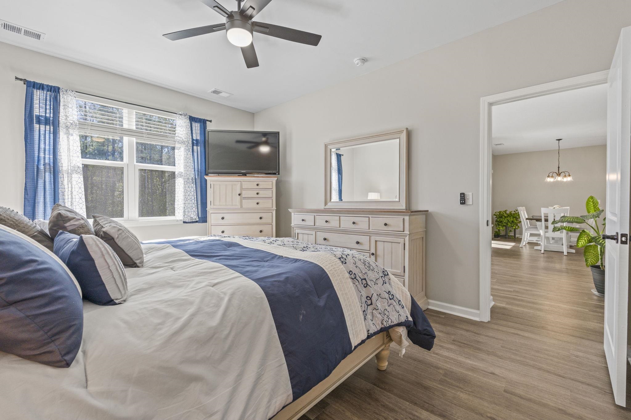 143 Ardeer Court Little River, SC 29566 - Photo 17 of 40 Bedroom featuring wood finished floors, a ceiling fan, and a chandelier