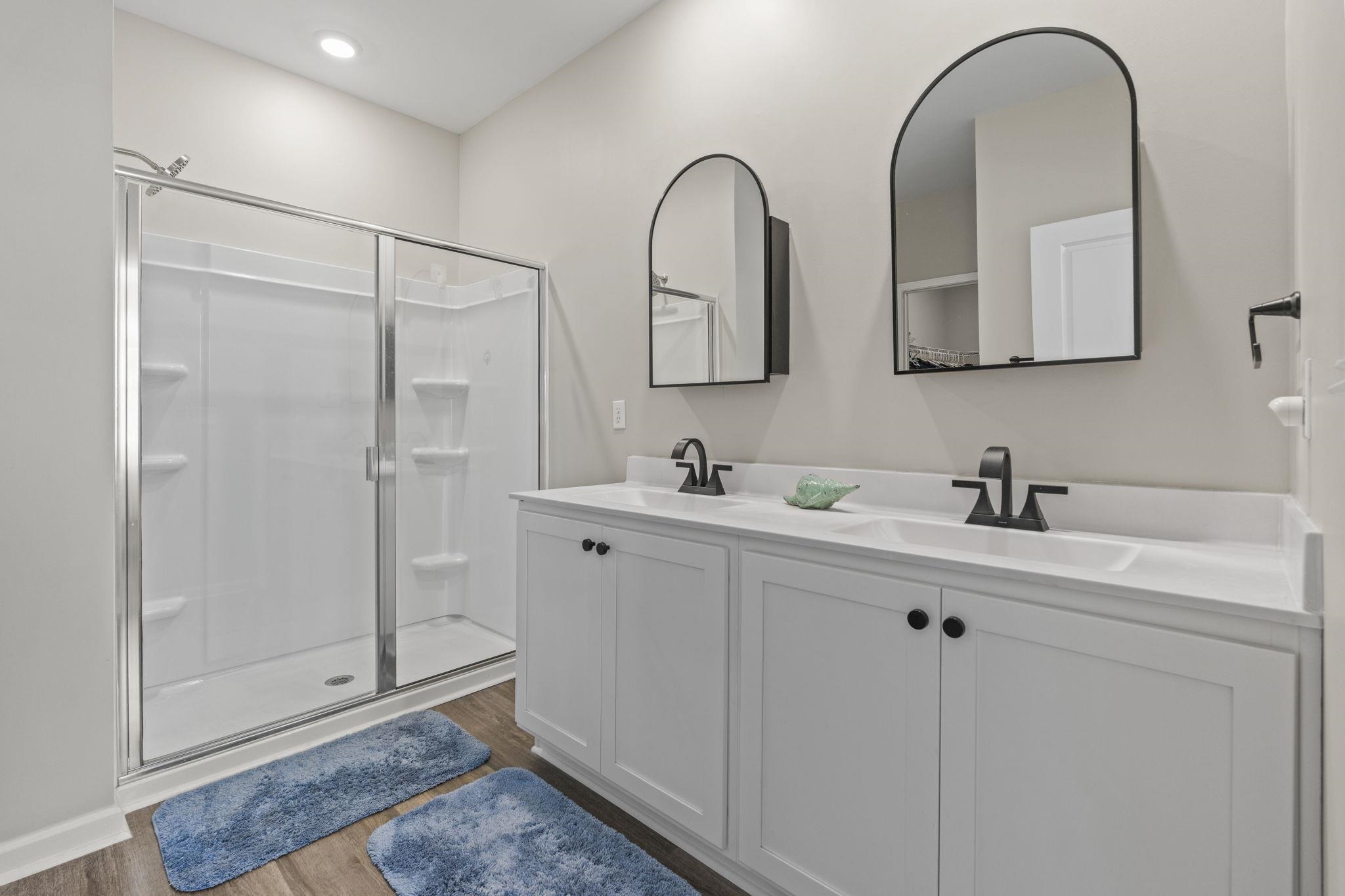 143 Ardeer Court Little River, SC 29566 - Photo 19 of 40 Bathroom with a stall shower, double vanity, and dark wood finished floors