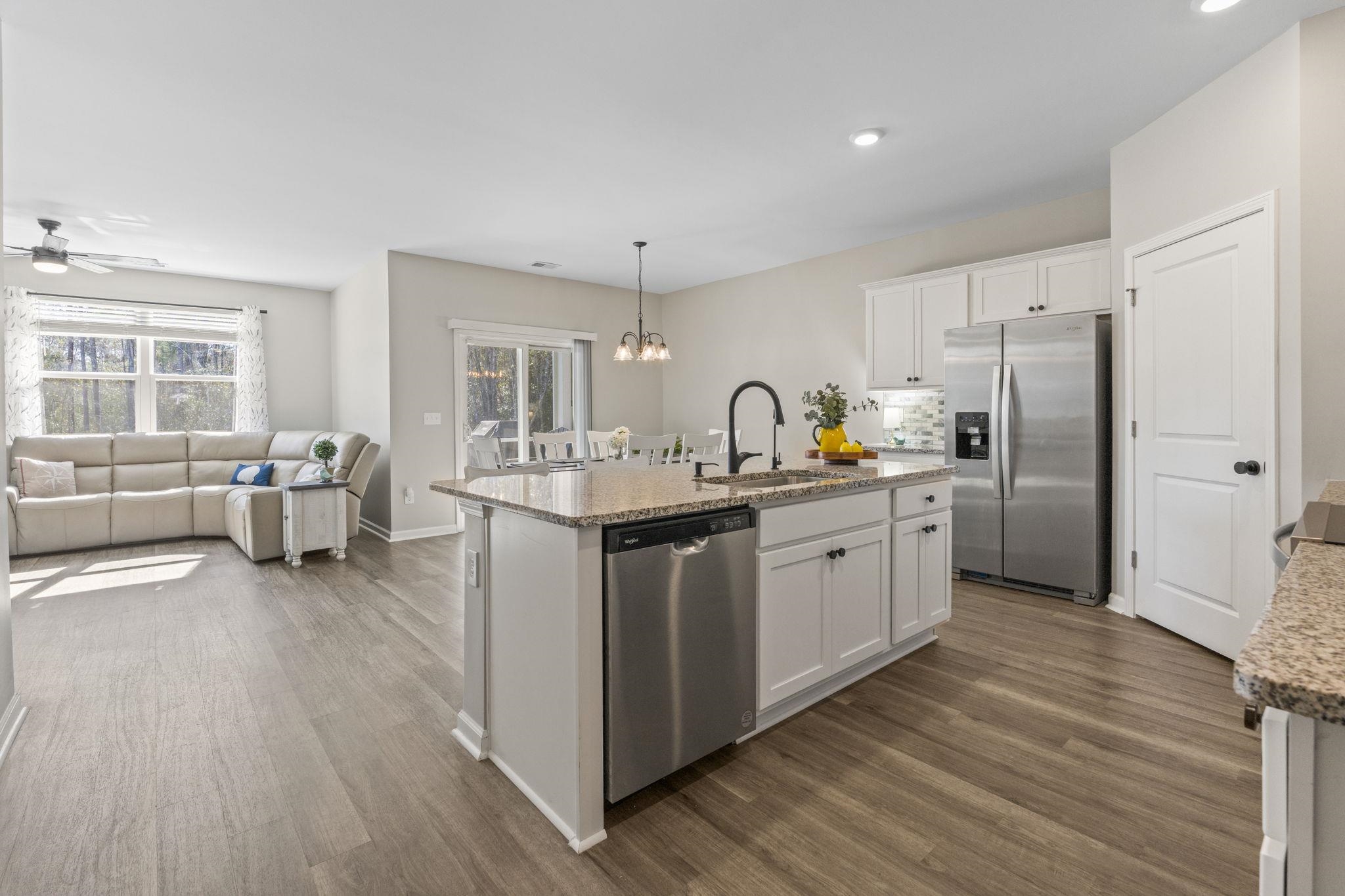 143 Ardeer Court Little River, SC 29566 - Photo 6 of 40 Kitchen with stainless steel appliances, a chandelier, white cabinetry, light stone countertops, and hanging light fixtures