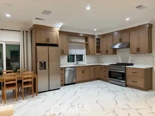 a kitchen with stainless steel appliances kitchen island granite countertop a refrigerator and a stove top oven