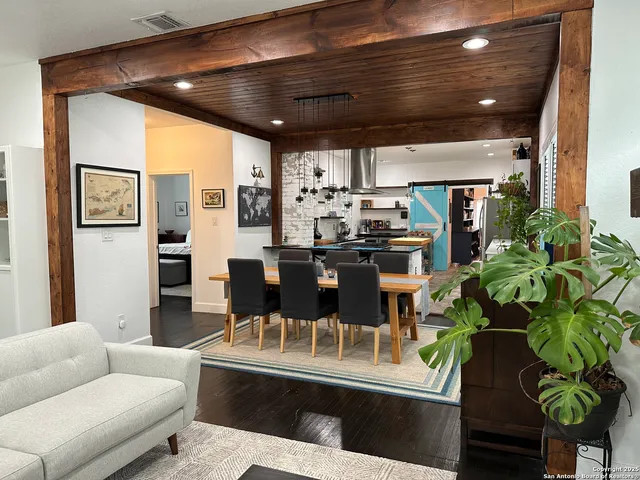 a dining room with furniture and a floor to ceiling window