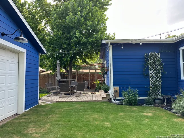 a view of a chair and table in backyard of the house