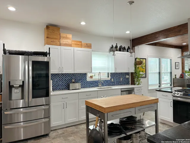 a kitchen with a refrigerator and a stove top oven