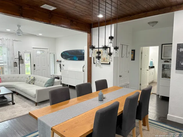 a living room with furniture and a dining table with kitchen view