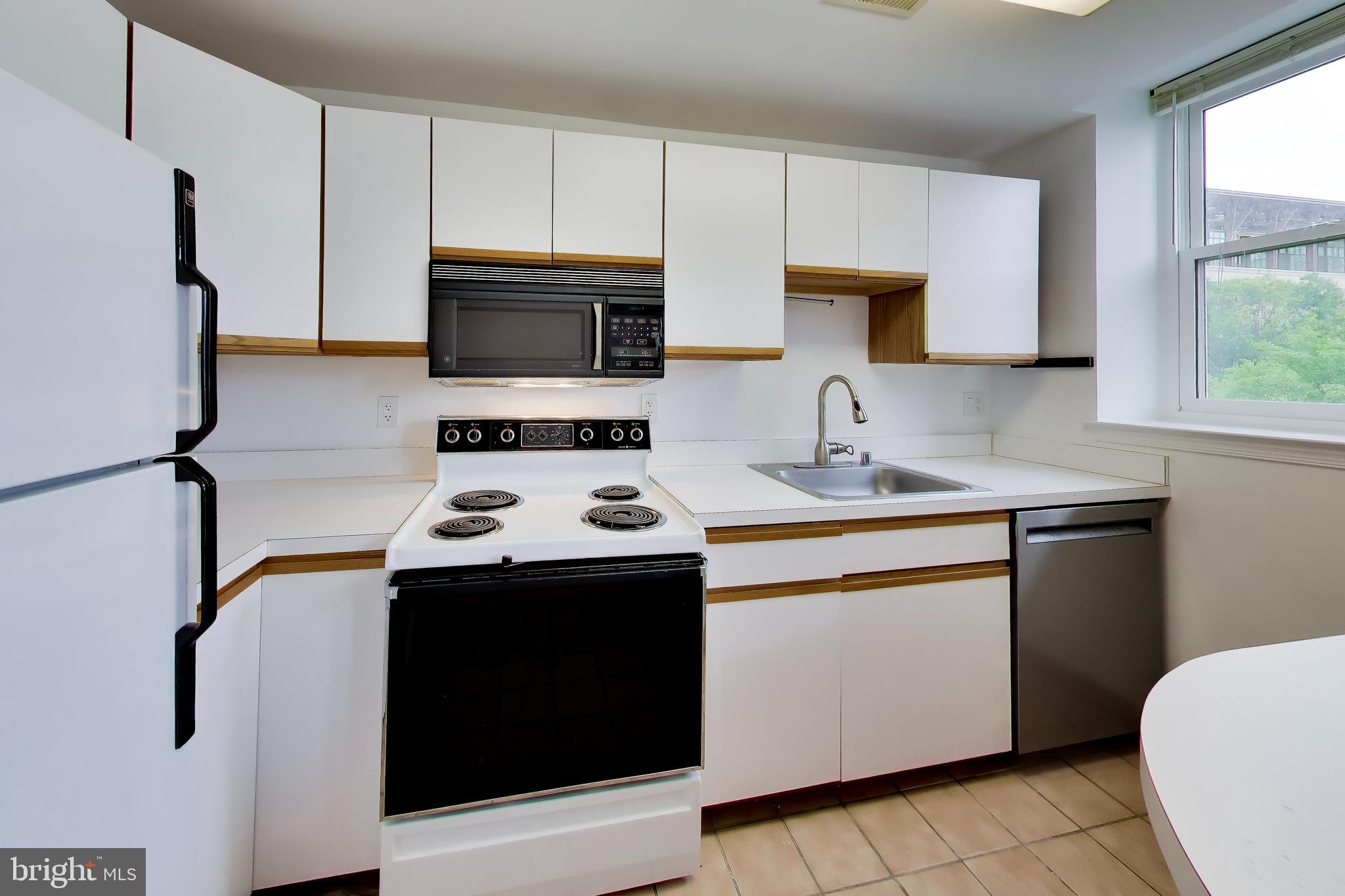 1920 S Street Northwest, Unit 403 Washington, DC 20009 - Photo 6 of 13 a kitchen with stainless steel appliances a stove microwave and sink