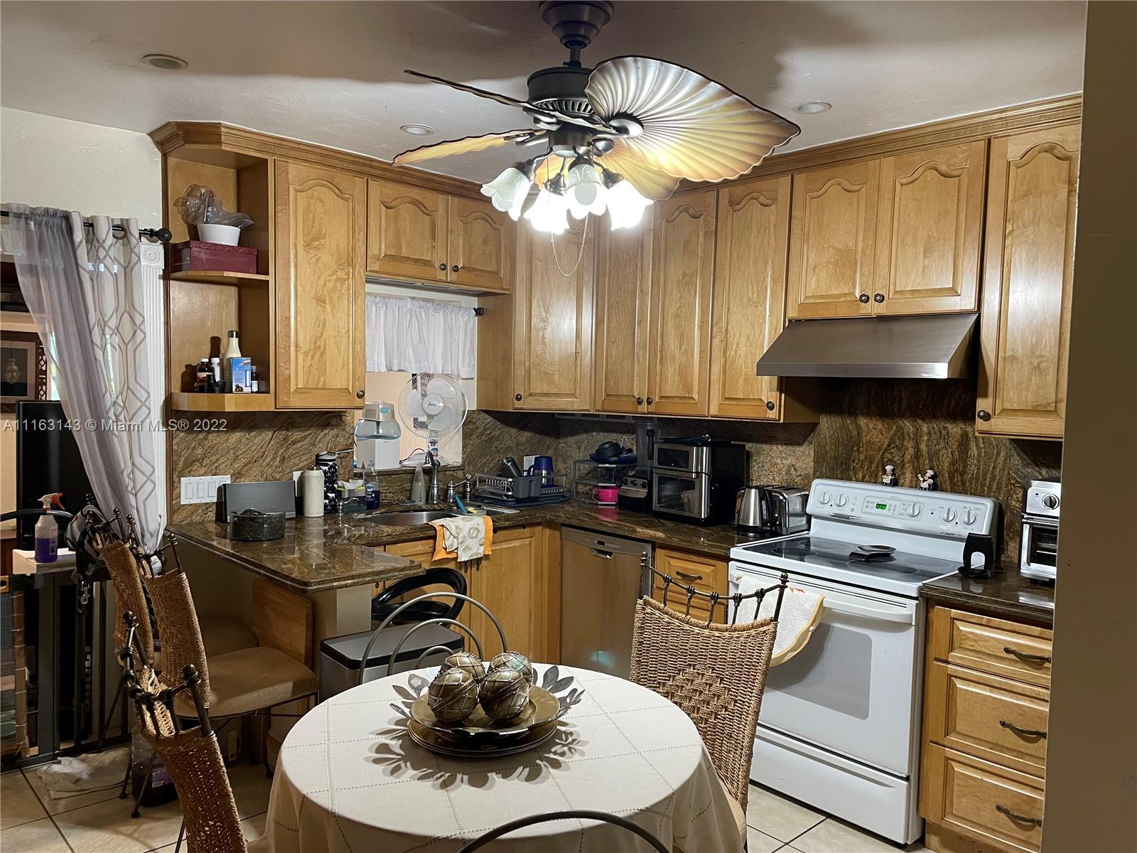 1111 Southwest 11th Avenue Miami, FL 33129 - Photo 12 of 28 a kitchen with a sink a stove and chairs