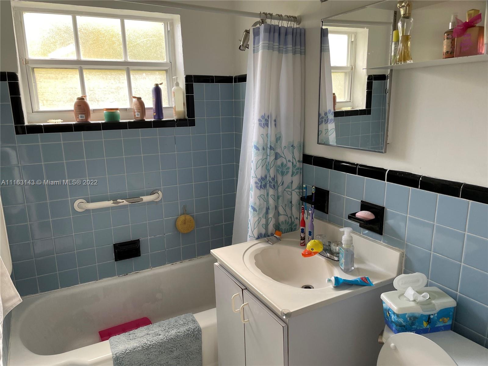 1111 Southwest 11th Avenue Miami, FL 33129 - Photo 27 of 28 a bathroom with a sink a toilet and a mirror