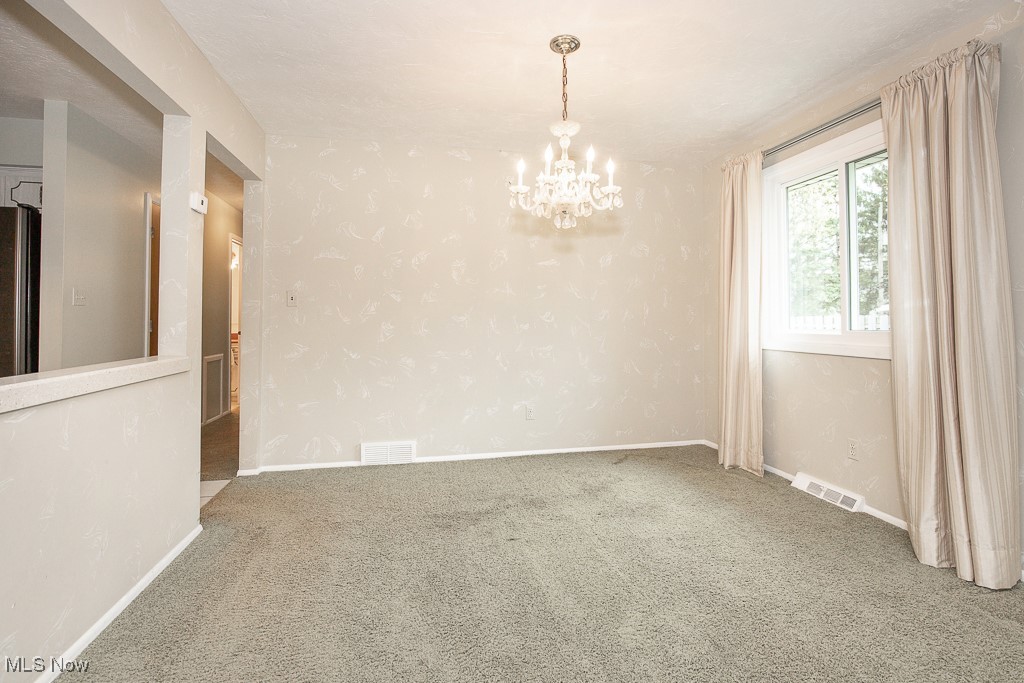 4569 McFarland Road Cleveland, OH 44121 - Photo 11 of 29 Unfurnished room featuring an inviting chandelier, carpet, visible vents, and baseboards