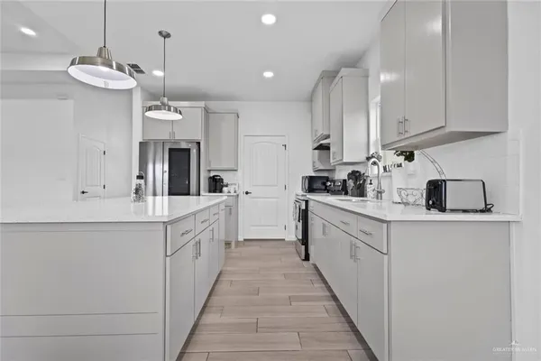 a large white kitchen with cabinets a sink and dishwasher