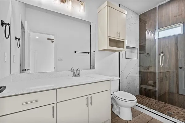 a bathroom with a sink a toilet and shower