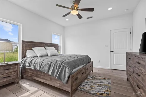a spacious bedroom with a bed and a chandelier
