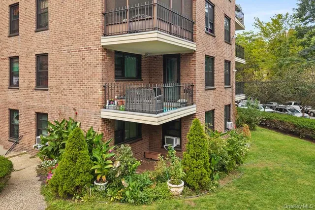 a view of a house with brick walls and flower plants