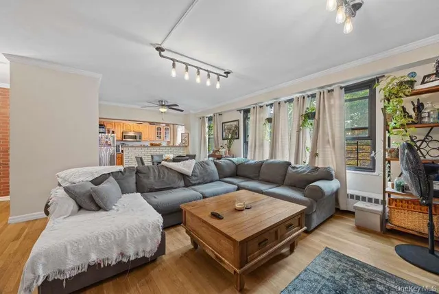 a living room with furniture a flat screen tv and a window