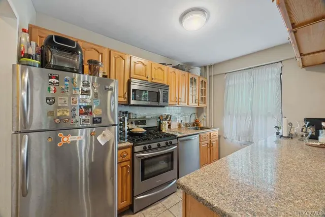 a kitchen with stainless steel appliances granite countertop a refrigerator stove top oven a sink and dishwasher