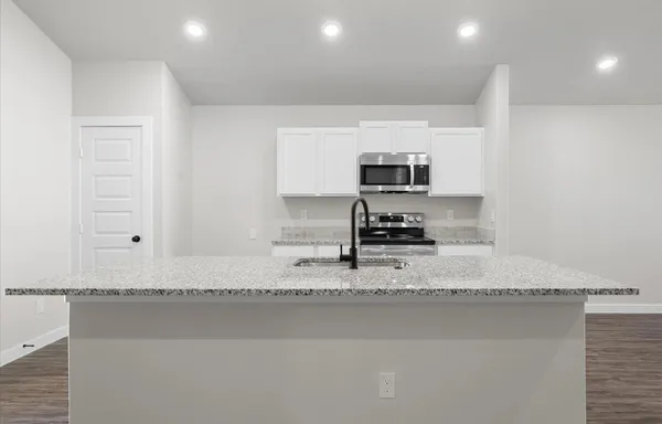 a kitchen with a sink a stove and a microwave