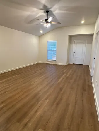 wooden floor in an empty room with a ceiling fan