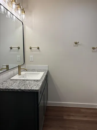 a bathroom with a granite countertop sink and a mirror