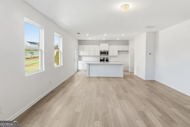 a view of kitchen with wooden floor electronic appliances and window