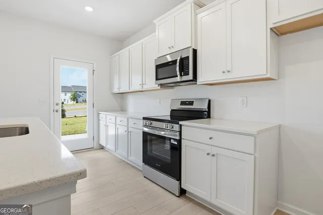 a kitchen with white cabinets stainless steel appliances and sink