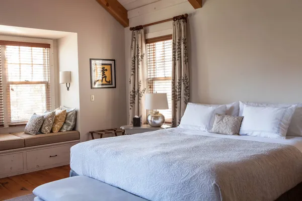 a bedroom with bed couch and window