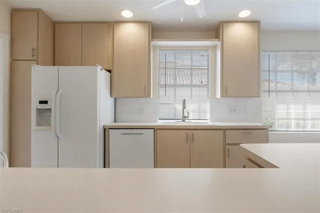 a kitchen with a refrigerator a sink and cabinets