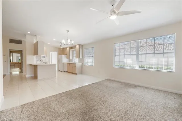 an empty room with chandelier and windows