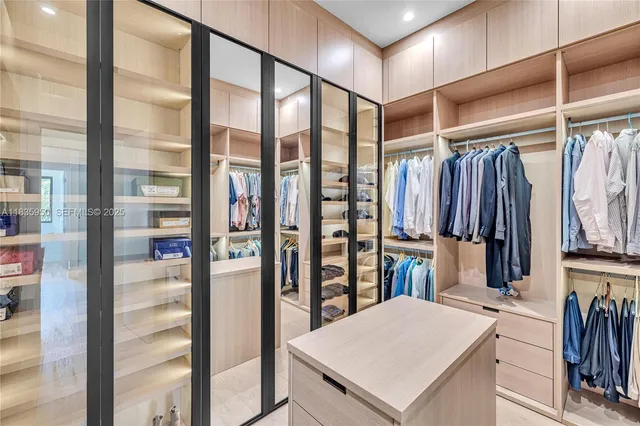 a view of walk in closet with clothes and shoes