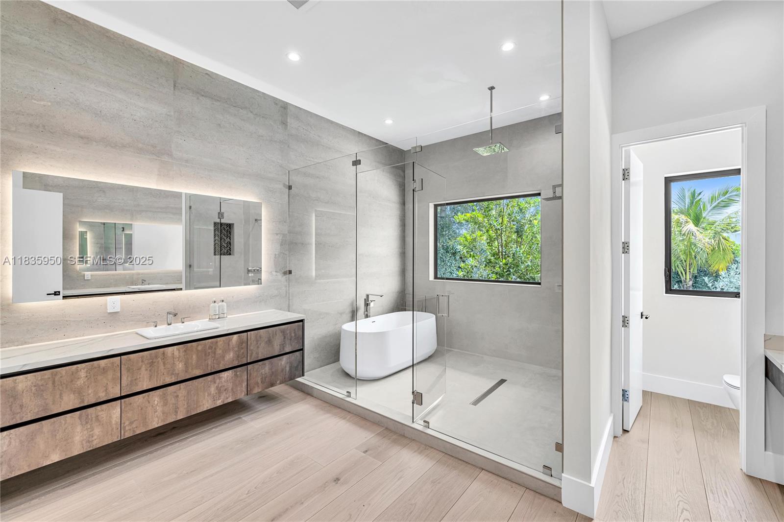 7699 Southwest 118th Street Pinecrest, FL 33156 - Photo 15 of 38 a bathroom with a tub sink and mirror