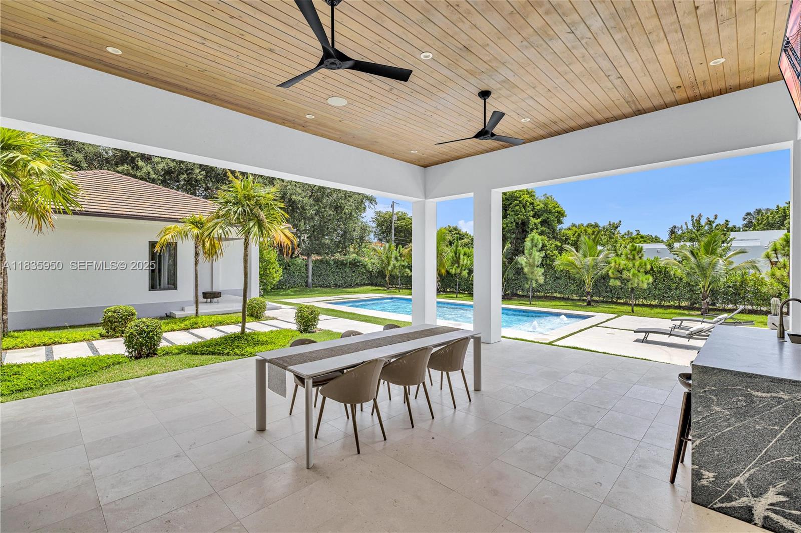 7699 Southwest 118th Street Pinecrest, FL 33156 - Photo 28 of 38 a patio with yard table and chairs