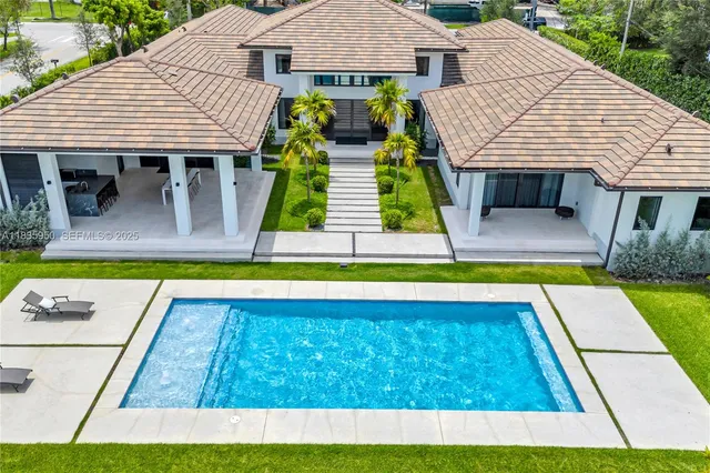 a view of house with swimming pool and glass windows