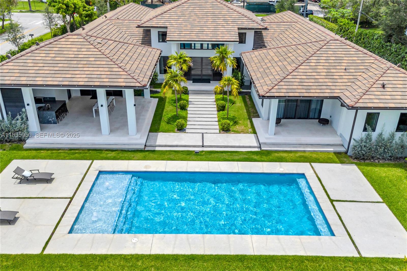 7699 Southwest 118th Street Pinecrest, FL 33156 - Photo 3 of 38 a view of house with swimming pool and glass windows