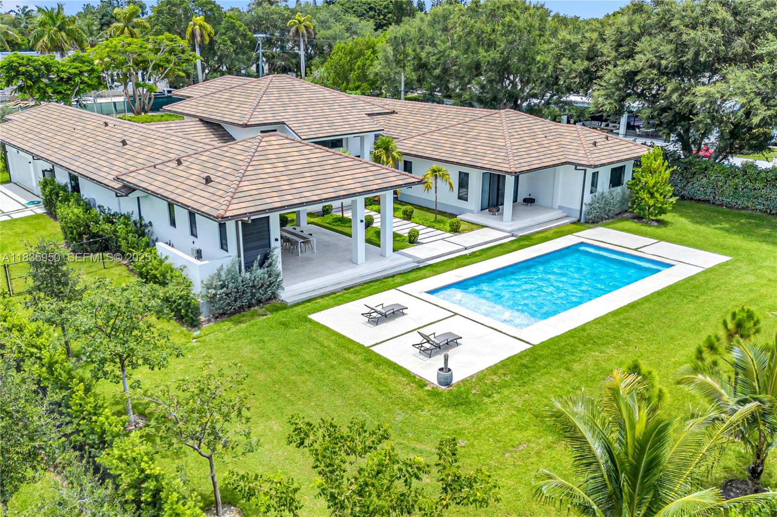 7699 Southwest 118th Street Pinecrest, FL 33156 - Photo 31 of 38 a view of a house with pool and chairs
