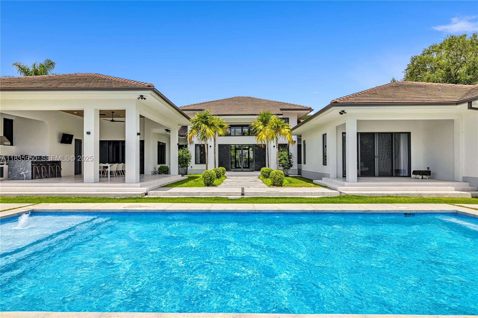 7699 Southwest 118th Street Pinecrest, FL 33156 - Photo 32 of 38 a view of an house with swimming pool and porch