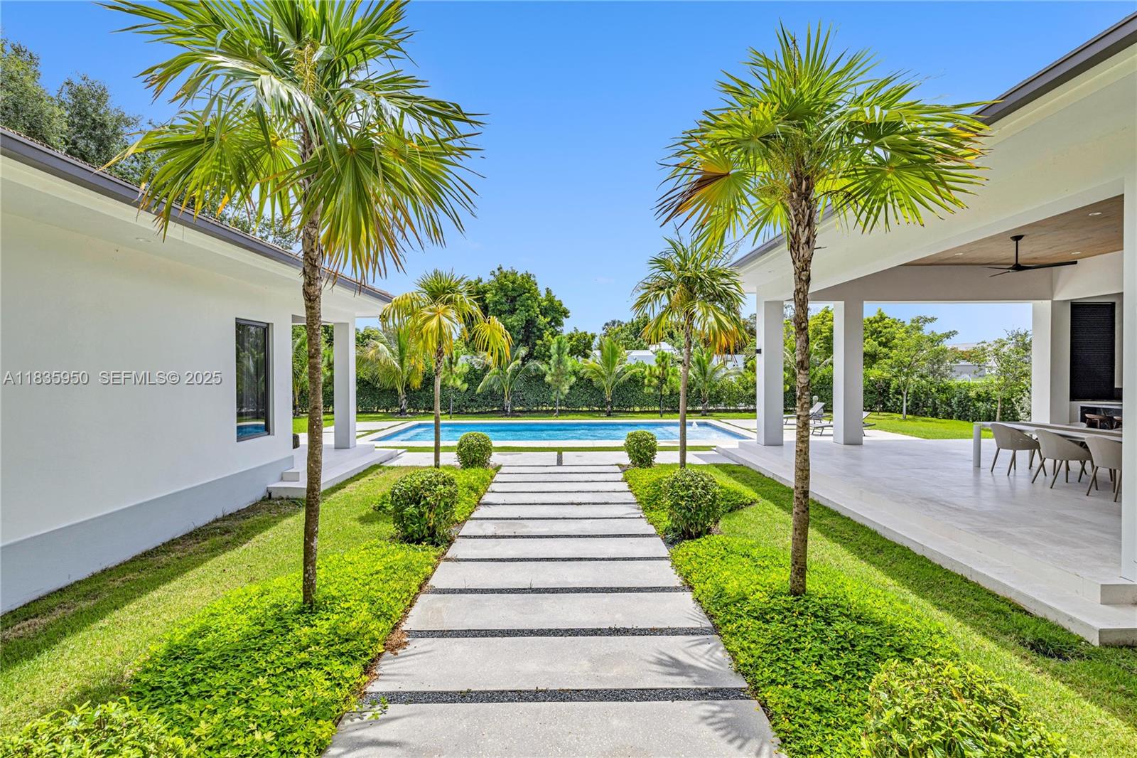 7699 Southwest 118th Street Pinecrest, FL 33156 - Photo 35 of 38 a view of swimming pool with a garden and patio