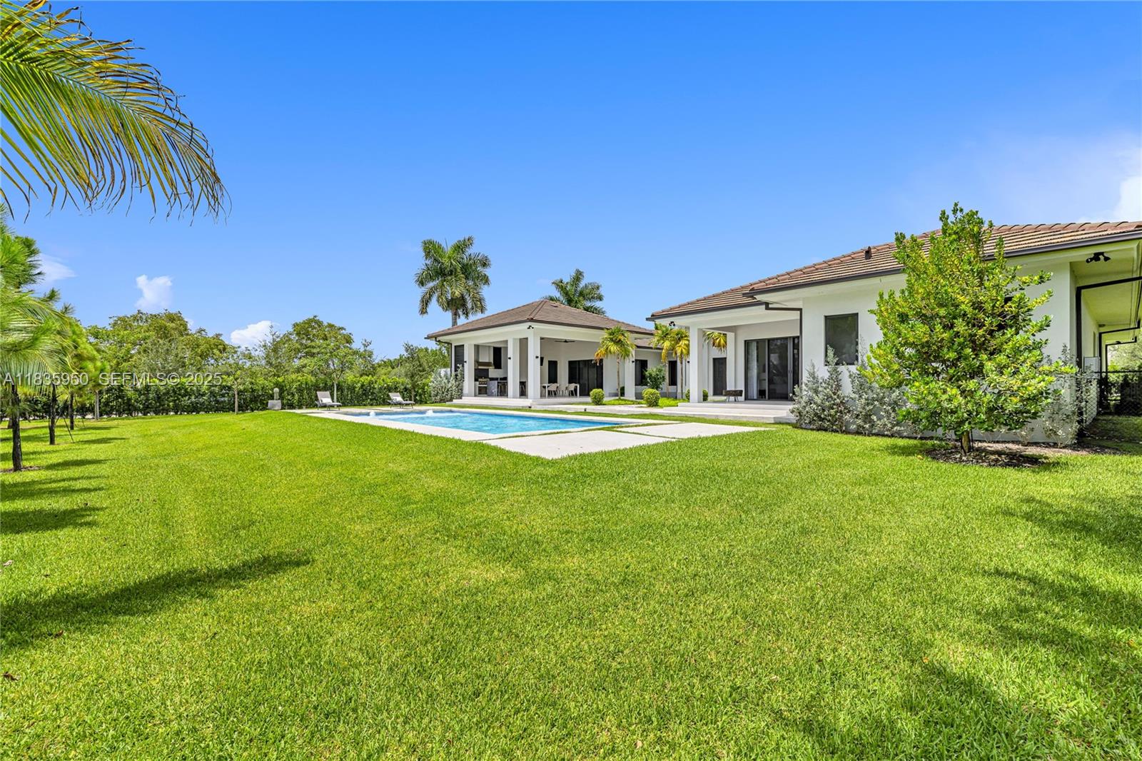 7699 Southwest 118th Street Pinecrest, FL 33156 - Photo 36 of 38 a front view of a house with a garden