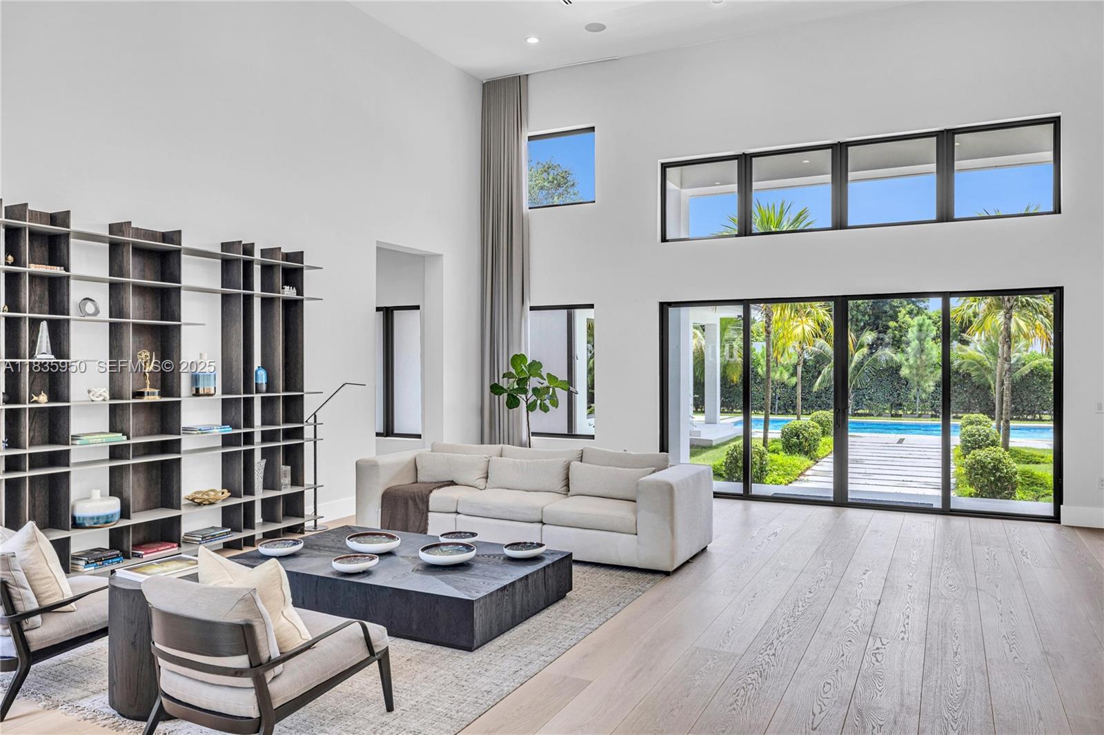 7699 Southwest 118th Street Pinecrest, FL 33156 - Photo 5 of 38 a living room with furniture and a floor to ceiling window