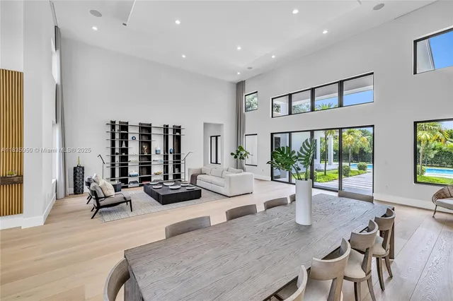 a living room with furniture large window and wooden floor