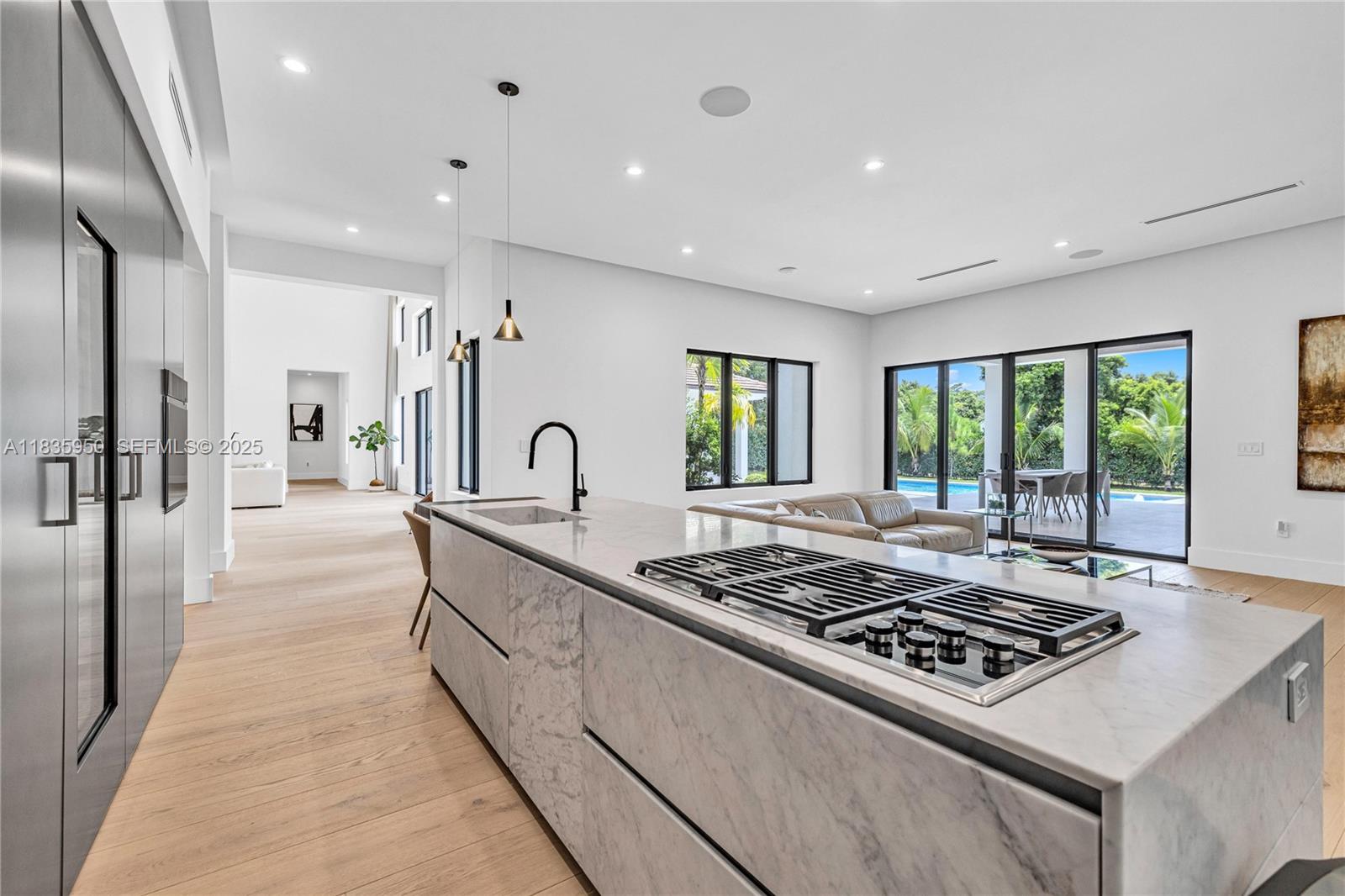 7699 Southwest 118th Street Pinecrest, FL 33156 - Photo 7 of 38 a large kitchen with stainless steel appliances granite countertop a stove a sink dishwasher a refrigerator and white cabinets with wooden floor