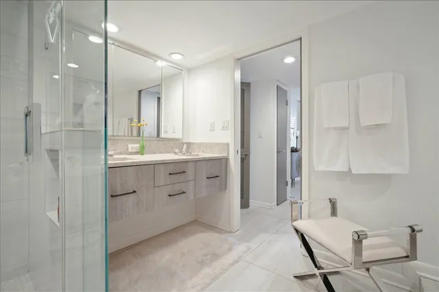 a bathroom with a double vanity sink mirror and shower