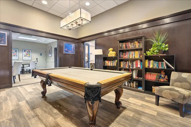 a living room with a table chairs and a book shelf