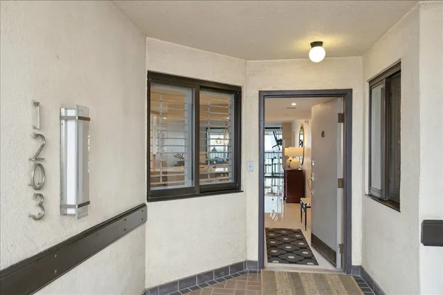 a view of a hallway with wooden floor and living room