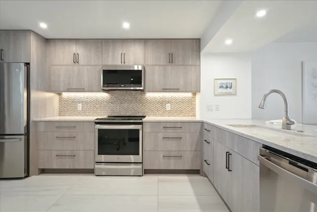 a kitchen with stainless steel appliances granite countertop a stove and a sink