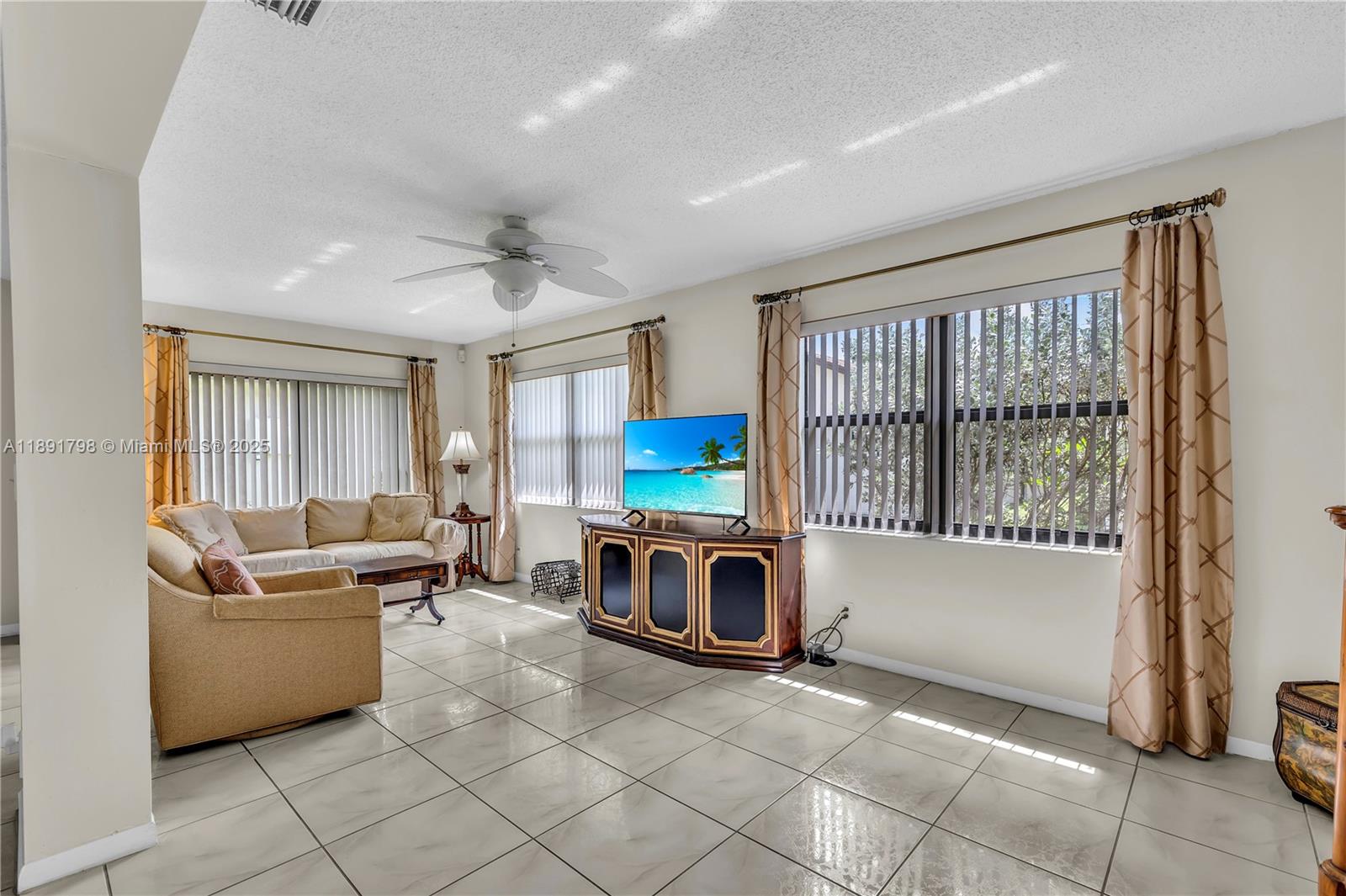 2000 Southwest 15th Place Deerfield Beach, FL 33442 - Photo 16 of 33 a living room with furniture a flat screen tv and a window