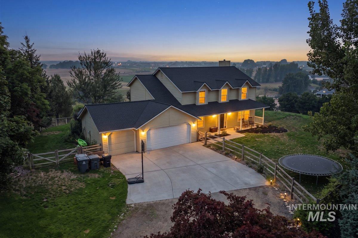 Two-story residence featuring dormer windows, a covered front porch, and an attached two-car garage