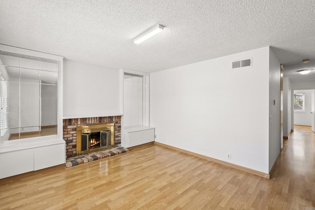 1850 Paradise Hills Road San Diego, CA 92114 - Photo 11 of 39 a view of empty room with wooden floor and fireplace