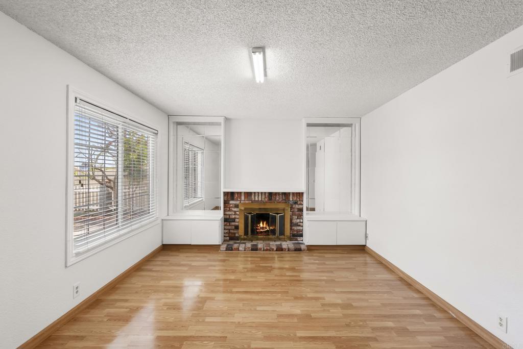 1850 Paradise Hills Road San Diego, CA 92114 - Photo 12 of 39 a view of empty room with wooden floor and fireplace